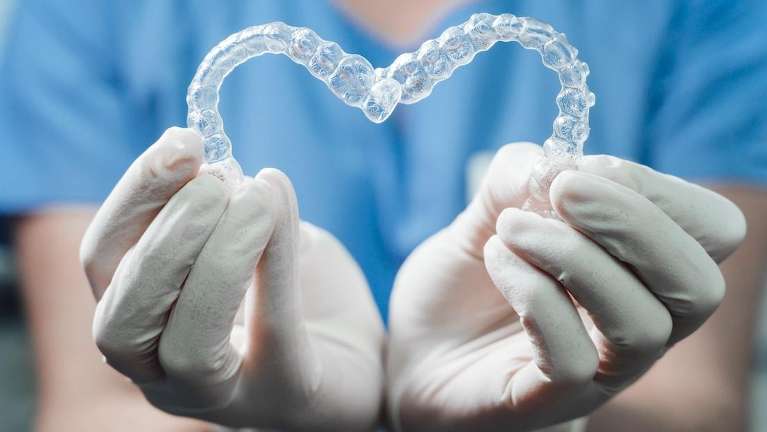 A dentist holding Clear Aligners in Burnaby