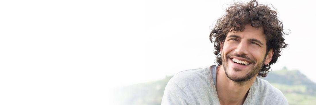 Man smiling after teeth replacement at Central Park Dental Clinic