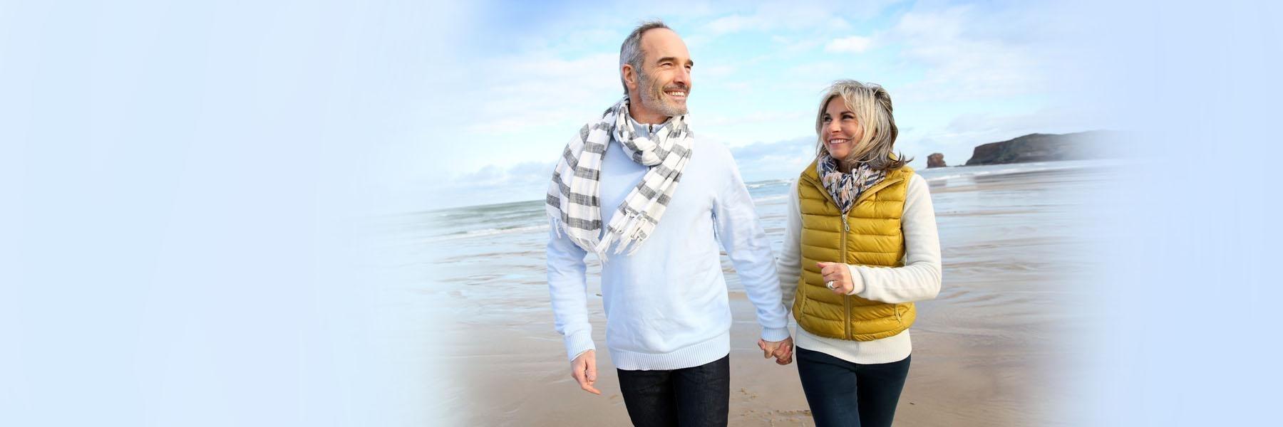 Older Couple walking on beach 