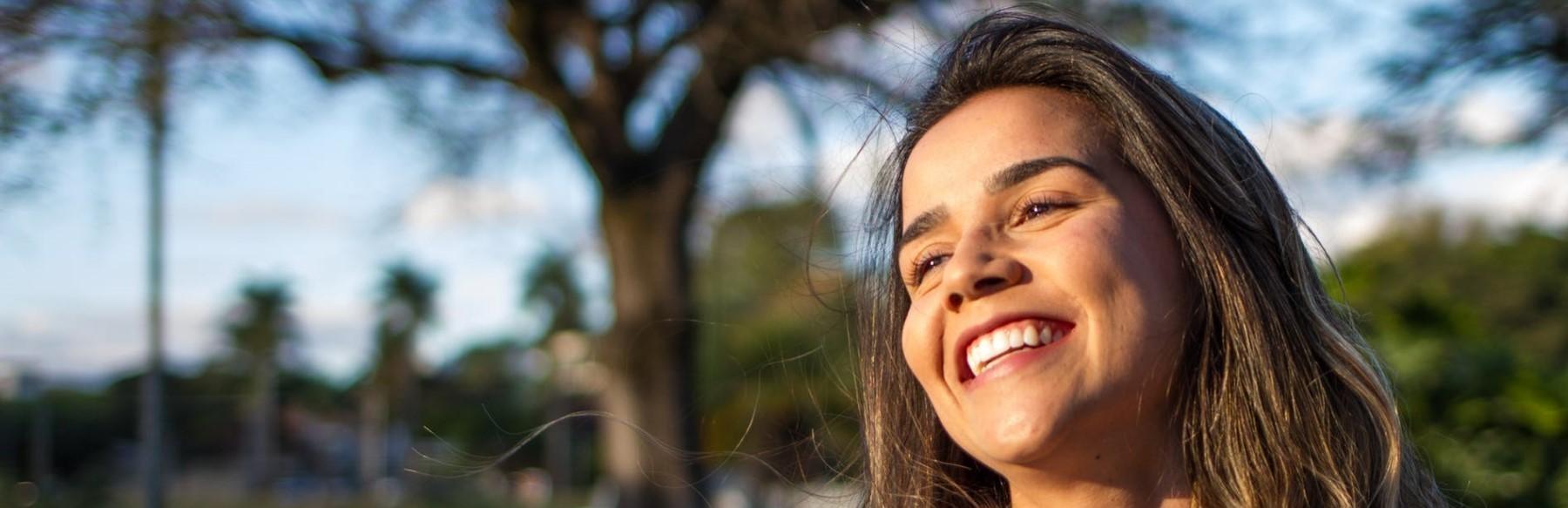 Woman smiling with trees in background