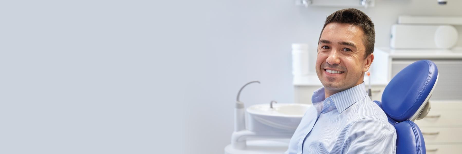 Man smiling in dental chair before cleaning